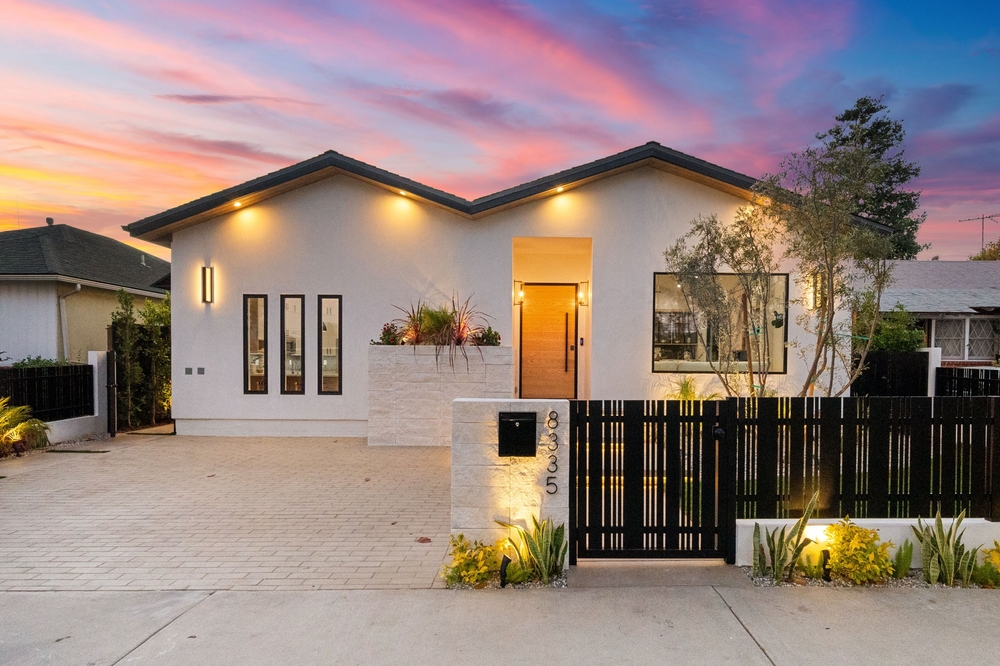Modern,House,Exterior,With,Illuminated,Facade,And,Vibrant,Sunset,Sky,